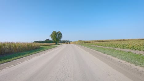 double time pov while driving on a gravel country road in rural iowa in early autumn