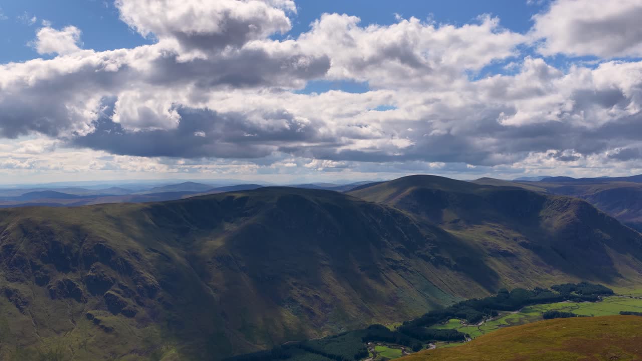 Un drone scivola sopra le Highlands scozzesi ricoperte di erica, rivelando ampie valli, nuvole suggestive e una luce solare soffusa
