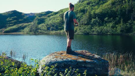 fisherman fishing in the river in indre fosen, norway - wide shot