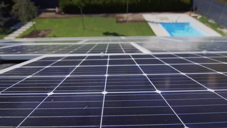 Paneles-Solares-En-El-Techo-De-La-Cabaña,-Al-Fondo-Un-Césped-Verde-Y-Una-Piscina