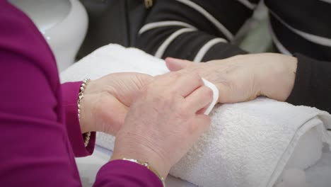 nagelpolieren der hand einer alten frau