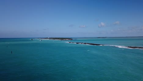 巴哈馬群島 (bahamas) 的海灘上,有一片藍色水漂浮在白色的沙子和岩石上