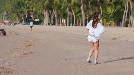 young girl joyfully runs along sandy beach