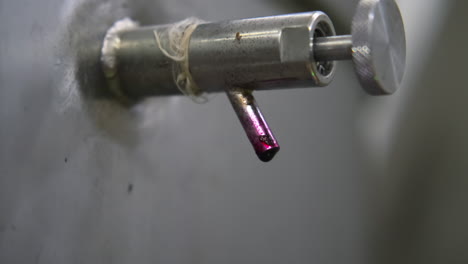 válvula industrial con goteo de líquido rojo