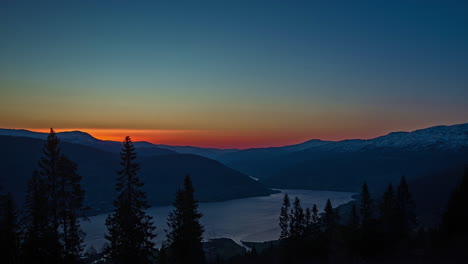 Toma-De-Lapso-De-Tiempo-Del-Amanecer-Dorado-Detrás-De-La-Cordillera-Y-Agua-Tranquila-Del-Fiordo-En-El-Valle