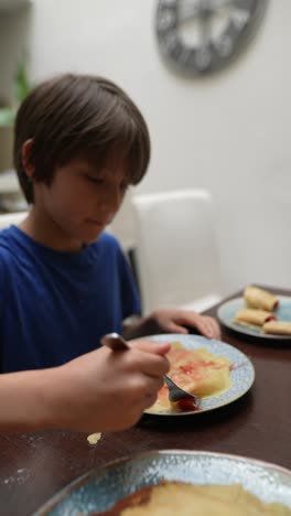 child eating strawberry pancakes