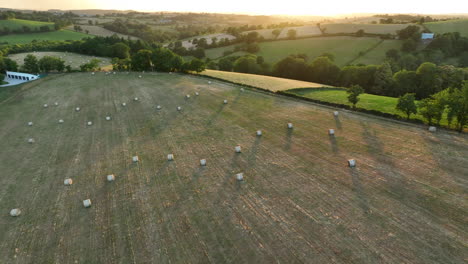 hay bales in farmland - aerial view countryside at sunset