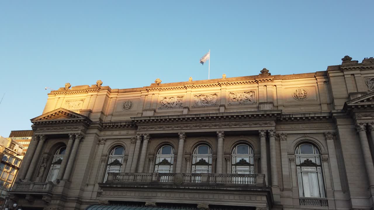 Panning view at Colon Theater, opera house of Buenos Aires Argentina, world famous location, National flag over Skyline
