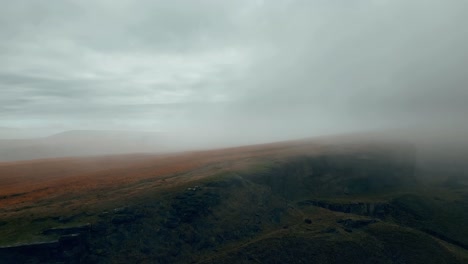 Luftdrohnenansicht-Von-Morgennebeln,-Die-Sich-Langsam-über-Die-Feuchten,-Schroffen-Pennine-Hügel-Bewegen,-An-Einem-Nebligen-Morgen,-Goldenen-Hügeln-Und-Wunderschönen-Felsigen-Klippen-Und-Moorlandschaften