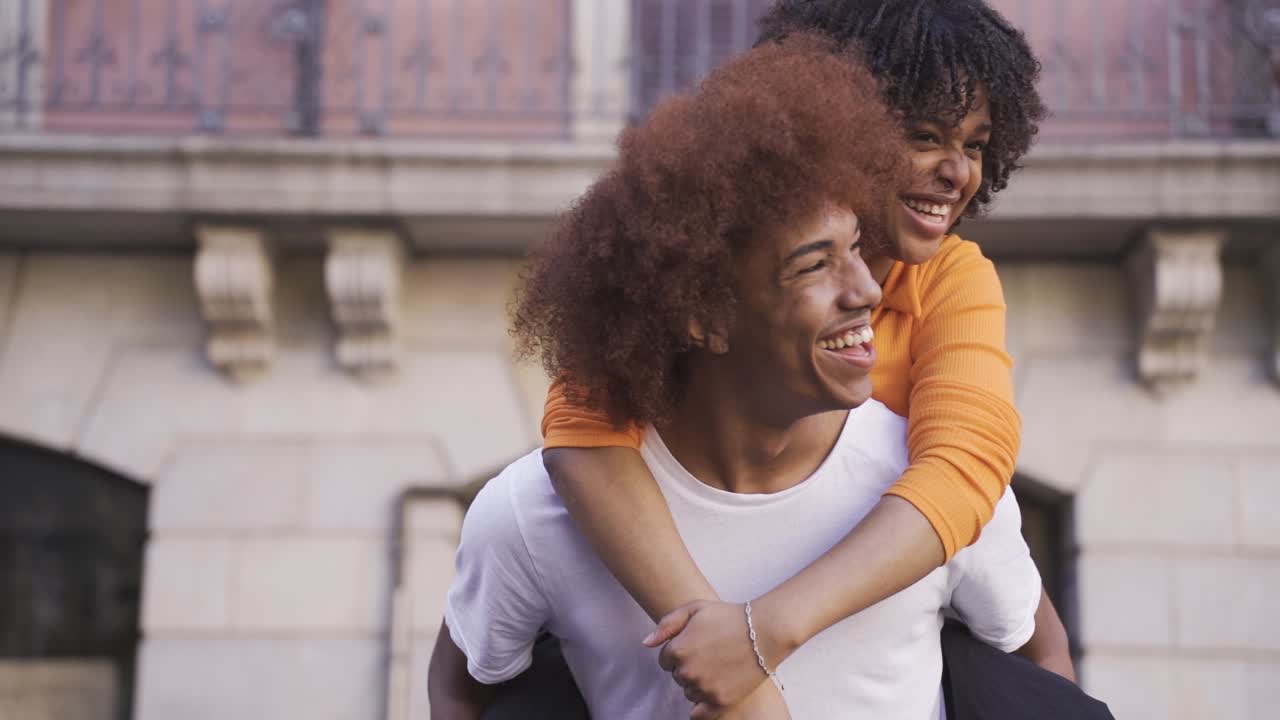 feliz pareja de jóvenes étnicos en la calle durante el día
