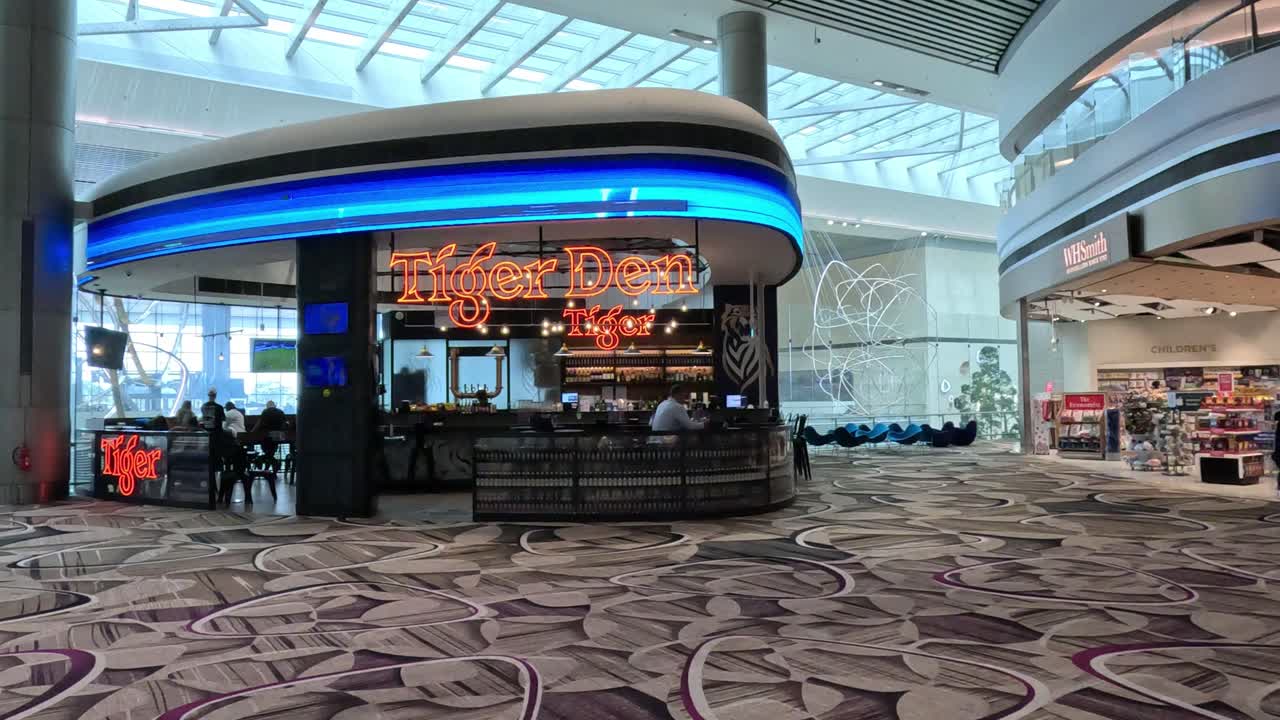 바쁜 공항 터미널의 승객들과 상점들.