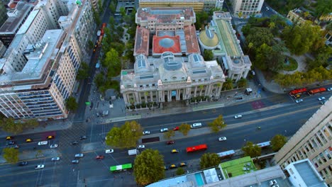 Arquitectura-Histórica,-Destino-De-Viaje-Cultural-Los-Autos-Conducen-Por-Avenida,-Drone-Aéreo-Vuela-Sobre-El-Edificio-Central-De-La-Biblioteca-Nacional-En-El-Punto-De-Referencia-Del-Gobierno-De-La-Ciudad-De-Santiago-De-Chile,-Tráfico