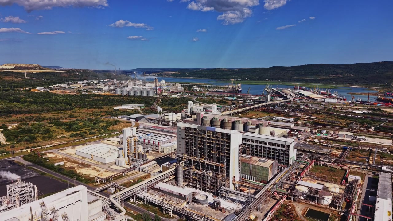 Industrial area by river with factories and cargo port during daytime