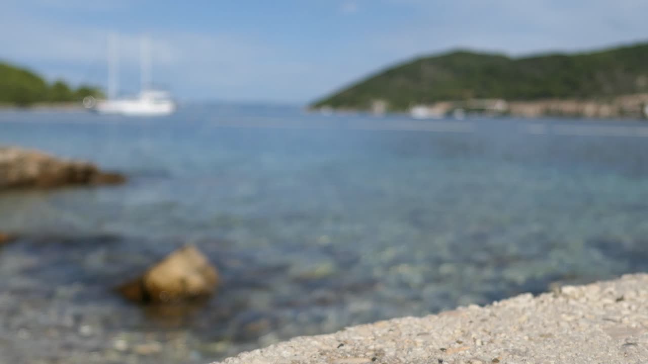 남자가 스노클링 마스크를 집어 들고 바다를 바라보는 배경, 지중해