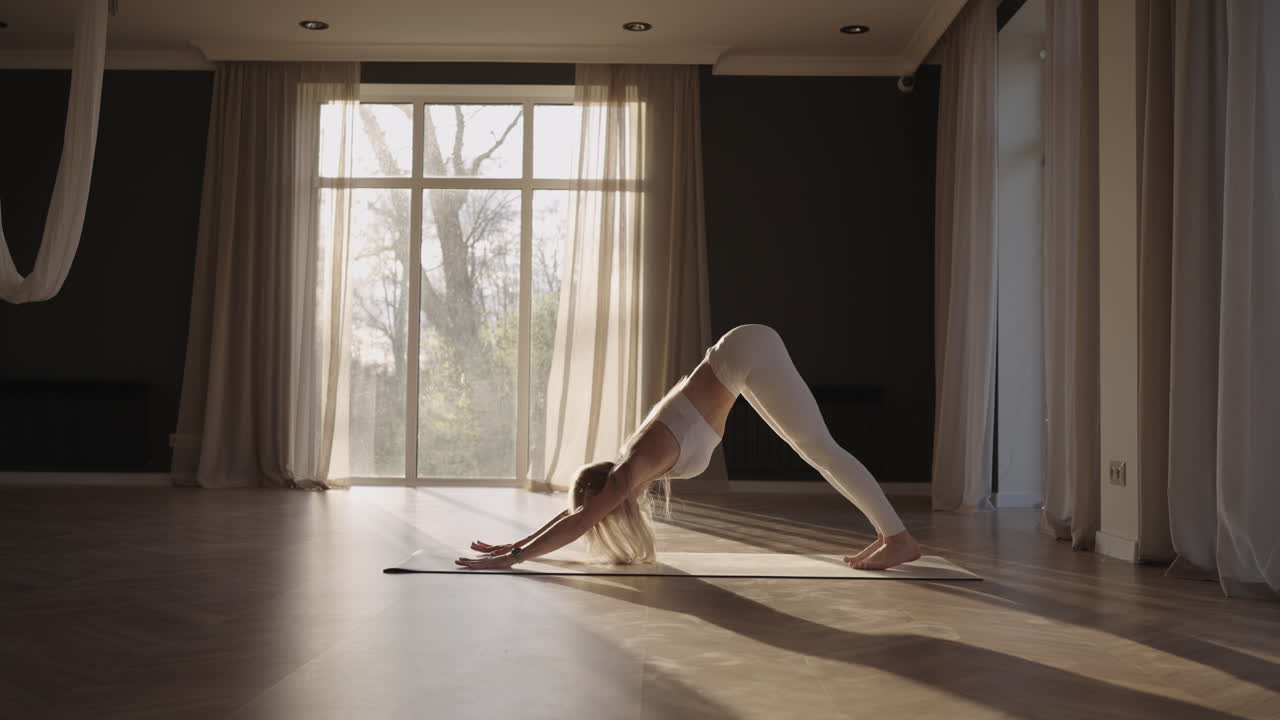 gesunde frau, die zu hause trainiert, yoga-posen im zimmer praktiziert, morgendliches fitness-training genießt