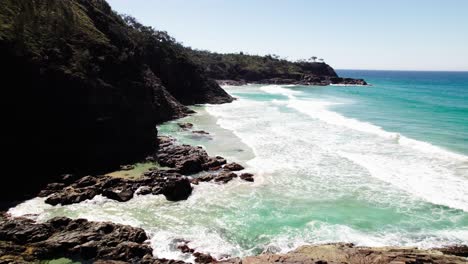 Playa-Idílica-Con-Olas-Espumosas-Y-Vegetación-Tropical-En-Noosa,-Queensland,-Australia---Retroceso-De-Drones