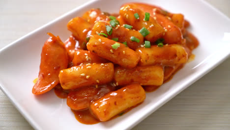 korean rice cake stick with sausage in spicy sauce - tteokbokki