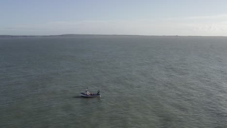 Vuelo-Aéreo:-Lado-De-Babor-De-Un-Pequeño-Barco-Pesquero-En-Mar-Plano-En-Alta-Mar