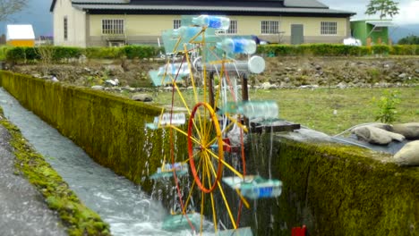 rueda hidráulica de bricolaje en el canal de riego girando en el sentido de las agujas del reloj para buscar agua