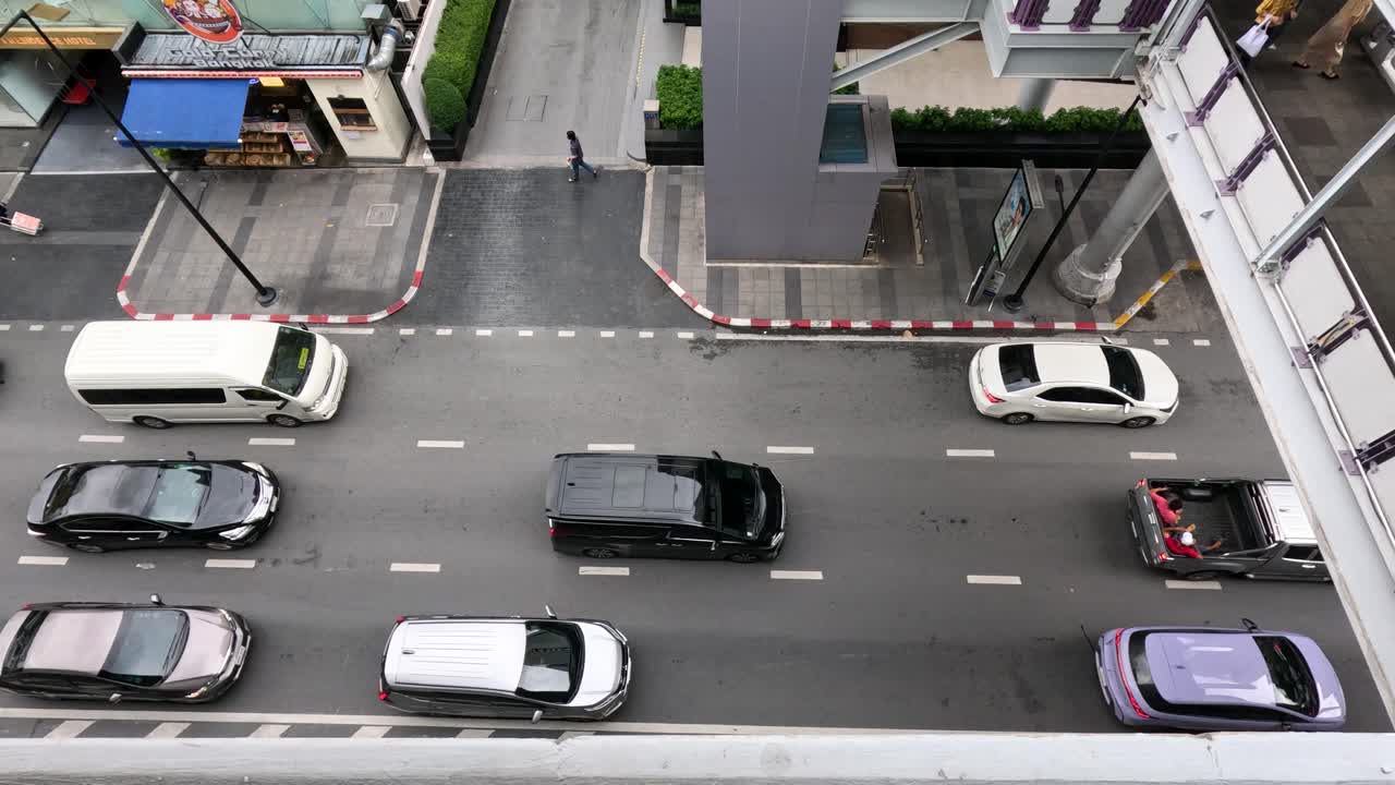 Overhead shot of Bangkok street as heavy traffic gradually clears, daylight, steady aerial perspective