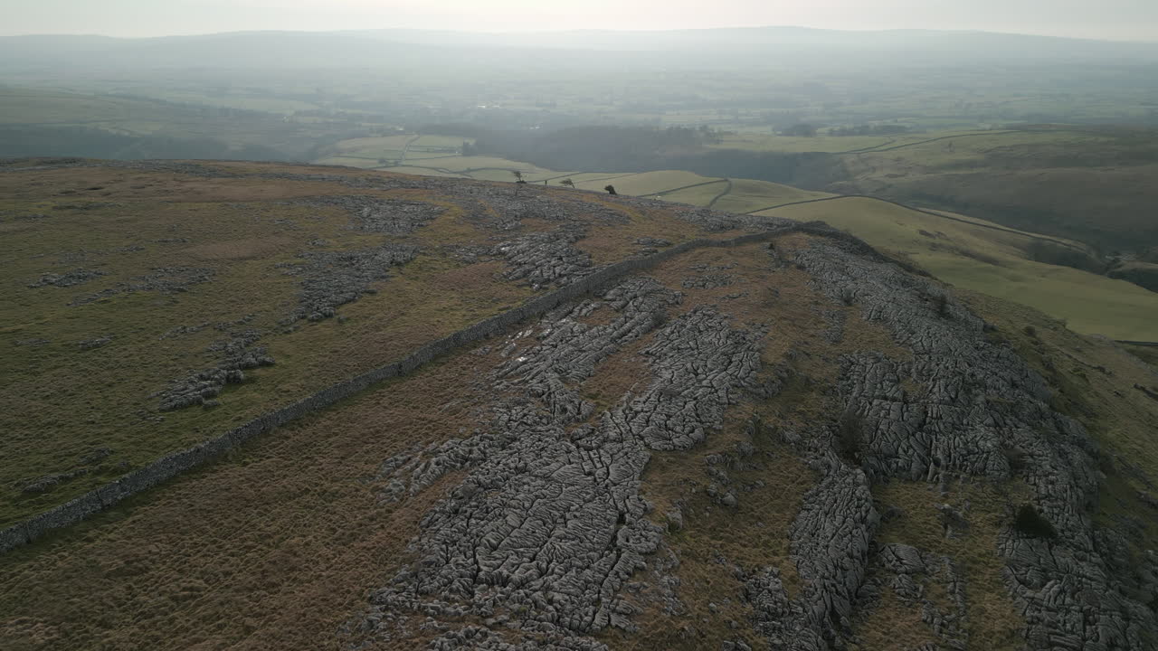 volando sobre la ladera y el pavimento de piedra caliza, revelando campos de retazos verdes en ingleton, yorkshire, reino unido