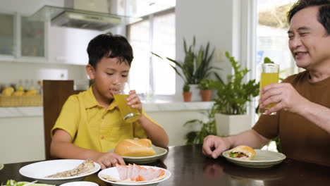 Hombres-Asiáticos-Y-Niño-Sentado-En-La-Mesa