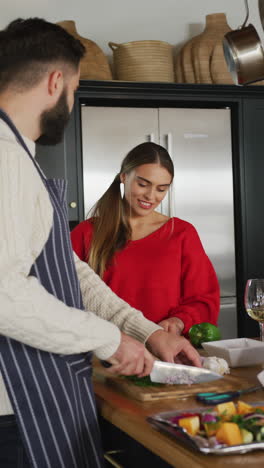 video vertical de una feliz pareja caucásica cocinando juntos