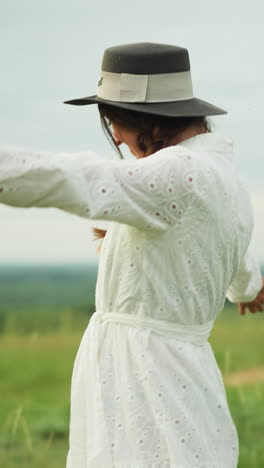 a joyful moment as a woman in a white dress and hat smiles while walking towards a man in a checkered shirt and hat, embracing him warmly in a lush, grassy environment
