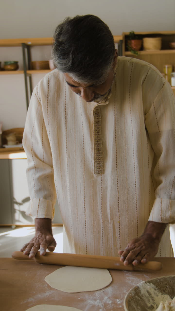 Elderly Man Cooking Indian Flatbread in His Kitchen
