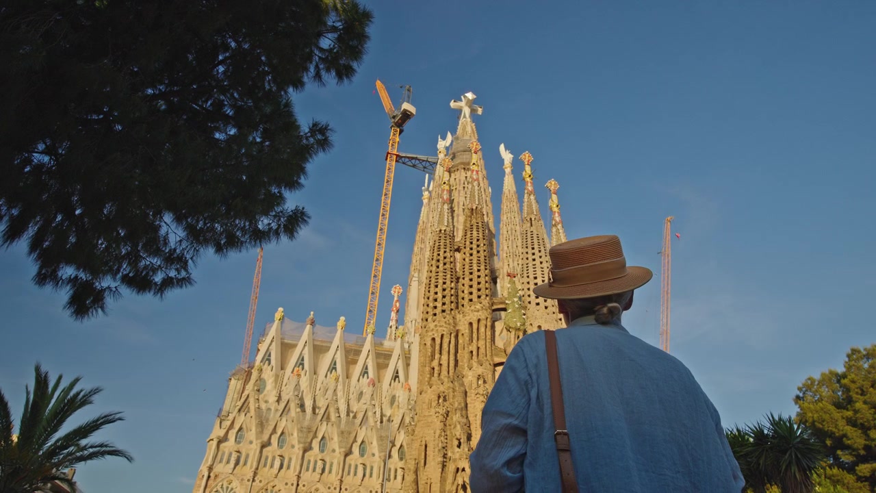 Viaggiatore con cappello che ammira la Sagrada Familia a Barcellona
