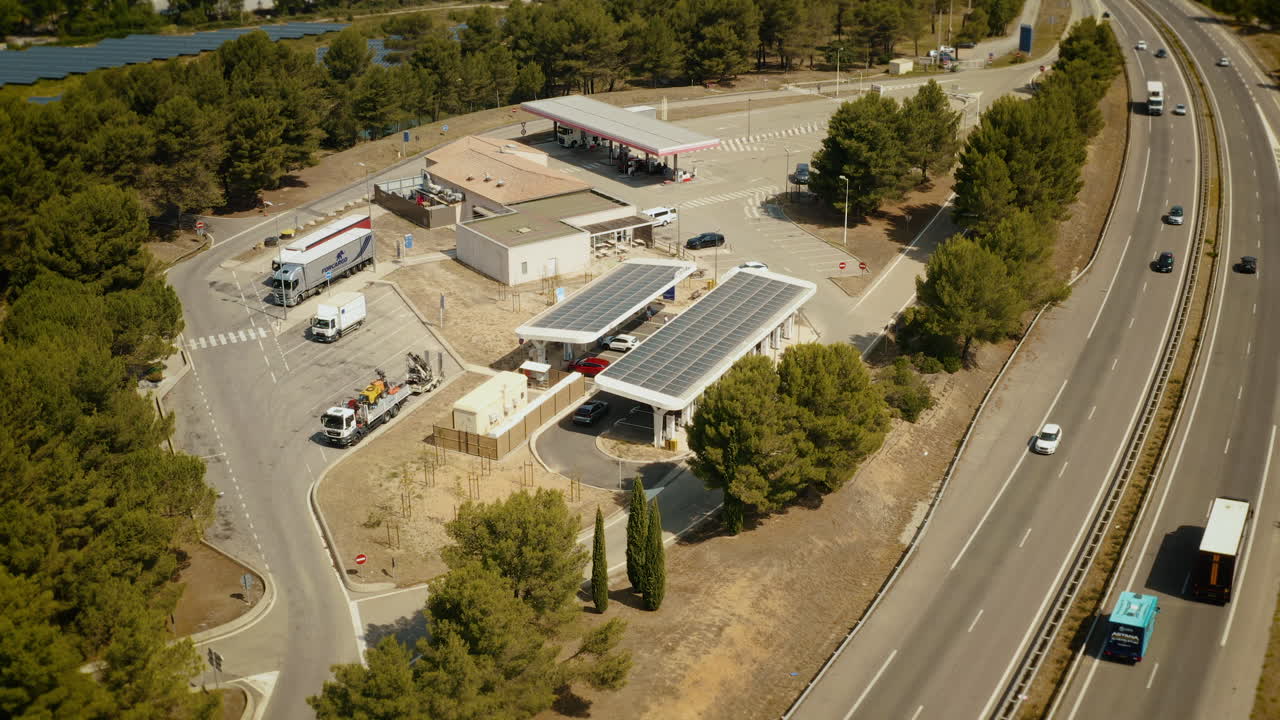 Aerial view of a highway service area with solar panels and gas station