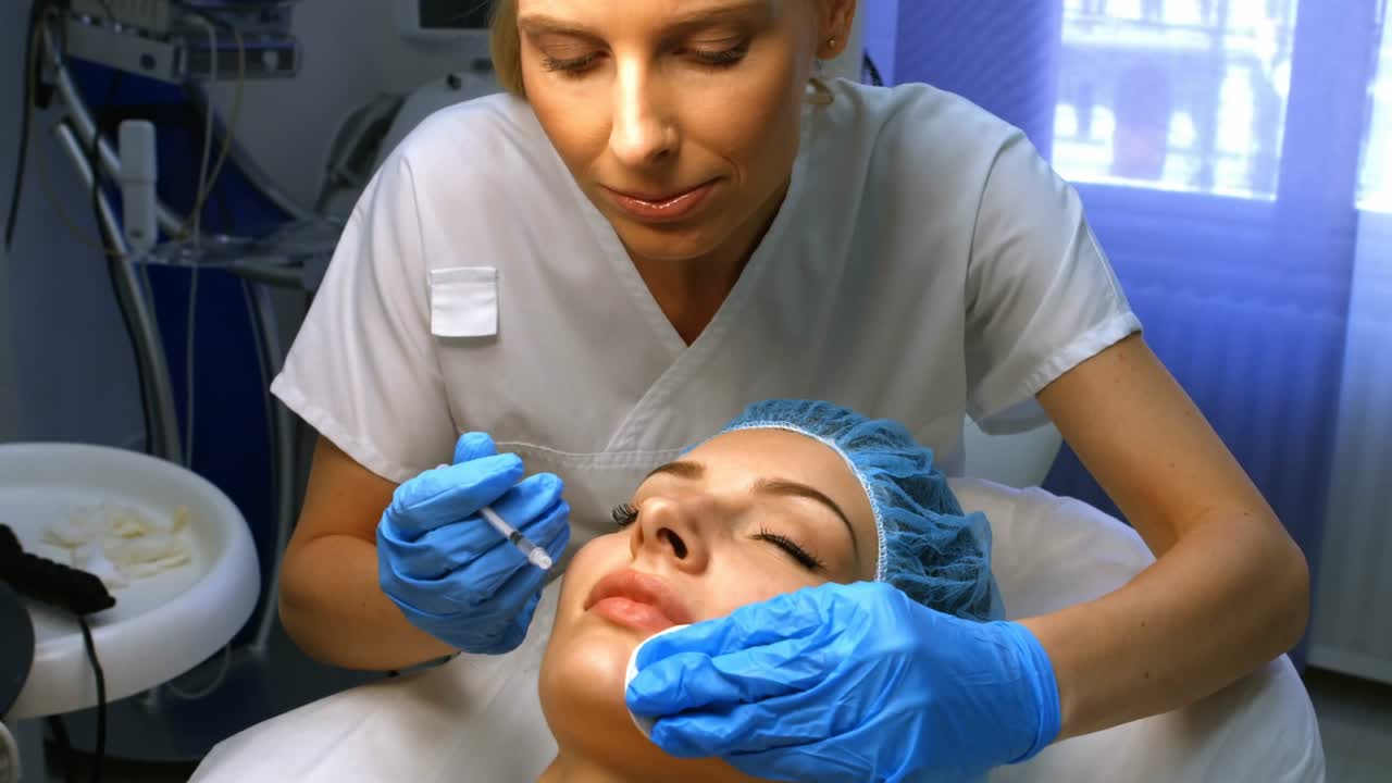Medico estetico che si sporge per iniettare filler labbra durante una diretta streaming con icone a forma di cuore che si moltiplicano