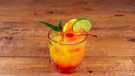 Close-up-of-a-mezcal-cocktail-being-placed-on-a-wooden-table-in-a-restaurant