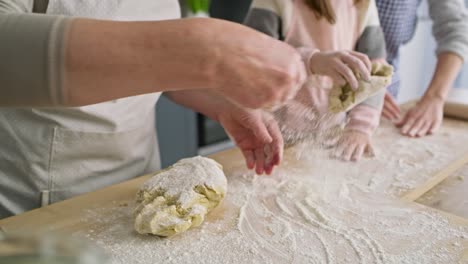 close up video of women sprinkling flour and kneading dough