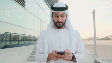 uae emirati man using mobile cell phone