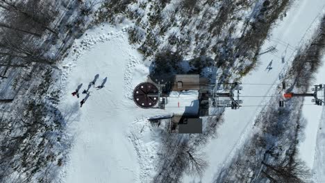 Top-down-shot-of-chair-lift-at-summit-of-mountain