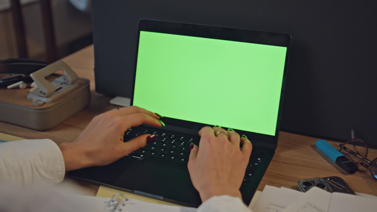 Manager hands typing mockup laptop examining documents at late workdesk closeup