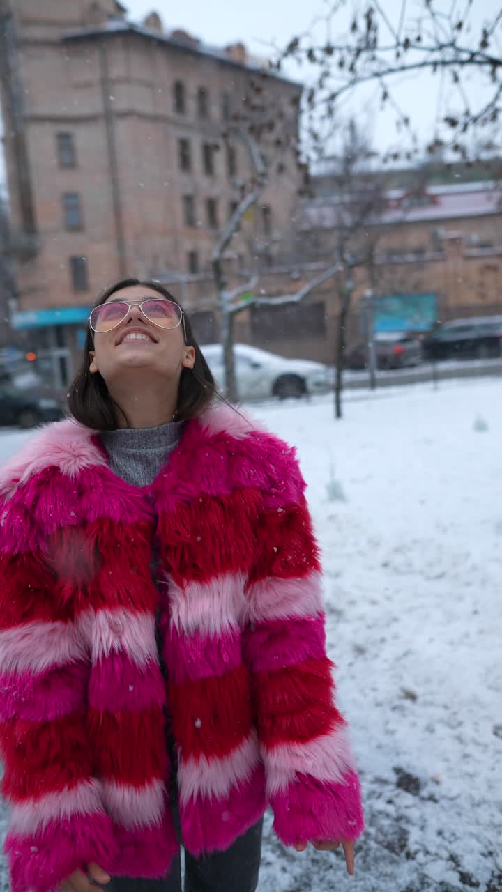mujer con abrigo de piel rosa en la nieve