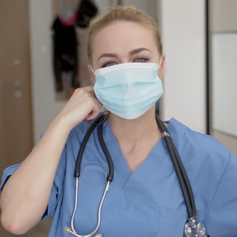 female doctor tired after long shift taking off her medical face mask with huge relief