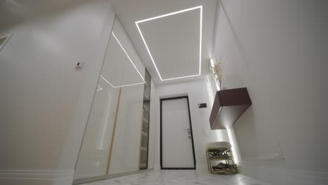 pasillo elegante y moderno con luces de techo de led geométricas, pisos de mármol y una estética minimalista
