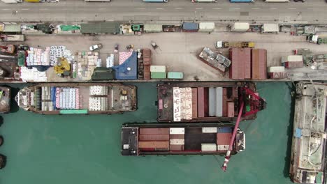 pequeñas barcazas de contenedores de tipo alimentador que operan en el muelle de pilar de hong kong