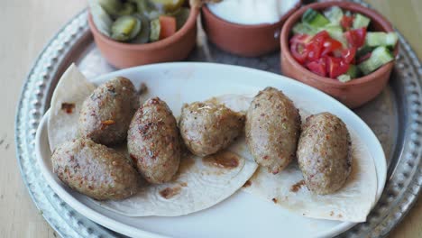 close up of turkish köfte meatballs with flatbread and salad