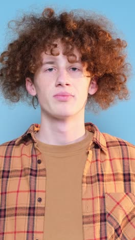 promotional video of a young guy with an interesting hairstyle on a blue background promotional video of a young guy with an interesting hairstyle on a blue background video shooting in the studio a calm focused young man