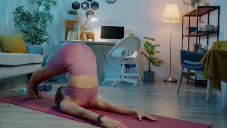 woman practicing yoga inversion pose at home