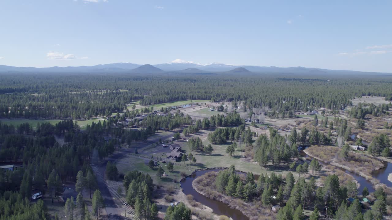 High slow pullback drone shot reveals the distant Three Sisters mountains in Bend, Oregon