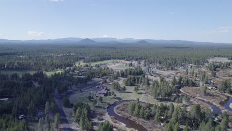 High-slow-pullback-drone-shot-reveals-the-distant-Three-Sisters-mountains-in-Bend,-Oregon