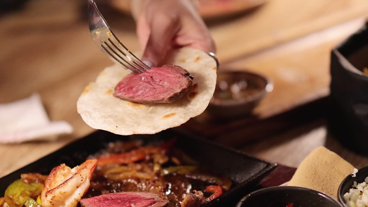 A sequence showing the preparation of beef fajitas with tortillas in a warmly lit restaurant environment