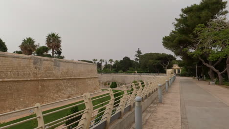 pov shot while walking along ancient medieval street in the town of mdina, malta on a cloudy day