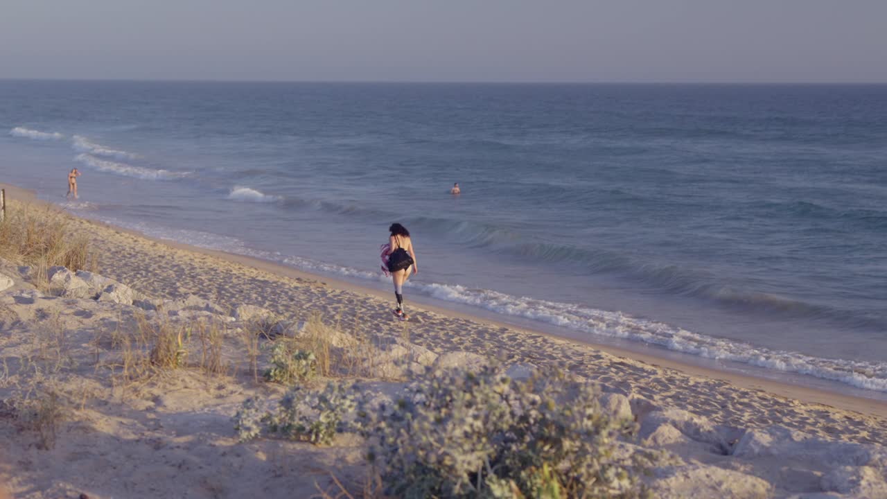해가 지면 해변에서 달리는 여자