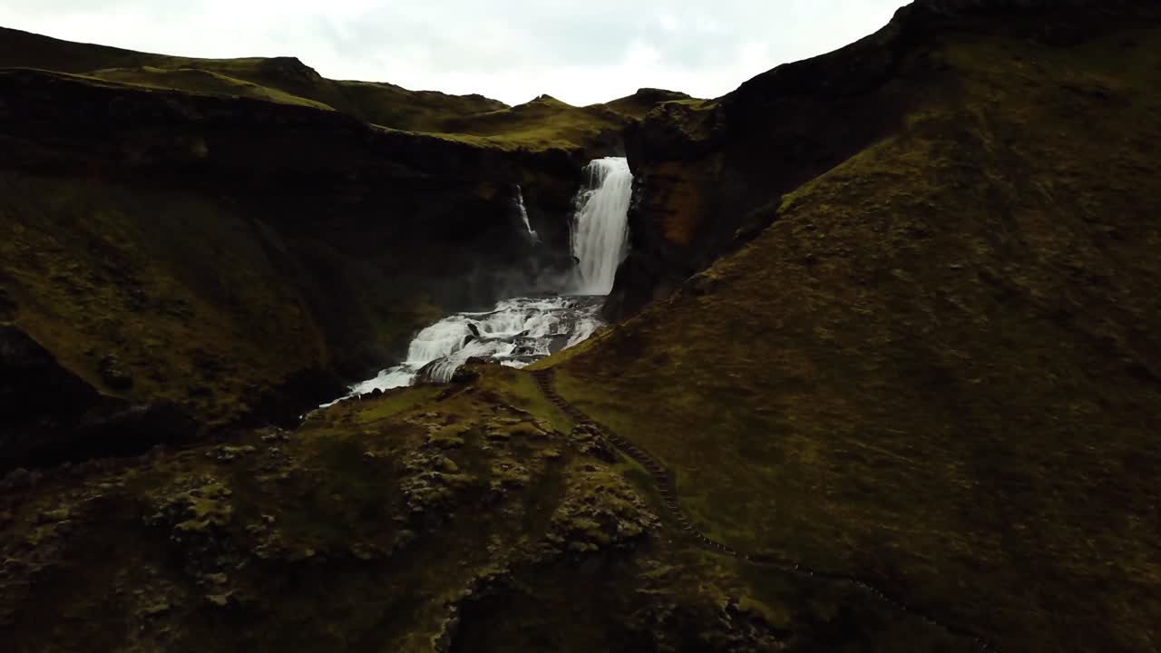 vista aérea panorámica de drones sobre el agua que fluye por la cascada ófærufoss, en las tierras altas de islandia